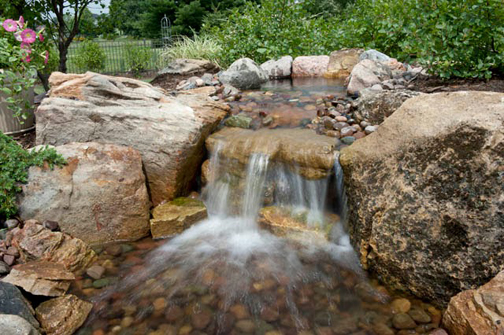 Even a small rustic waterfall such as this one can add drama and an air of rusticity to the landscape.